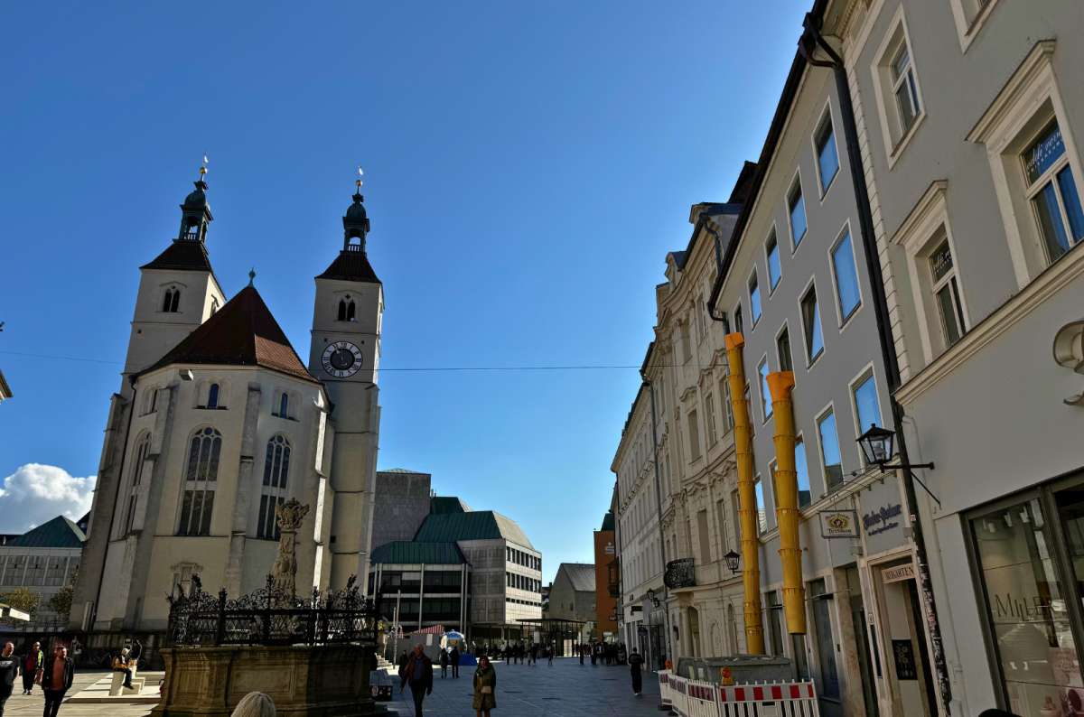 Neupfarrplatz in Regensburg with the twin towers of Neupfarrkirche, a historical fountain in front, photo by Next Level of Travel