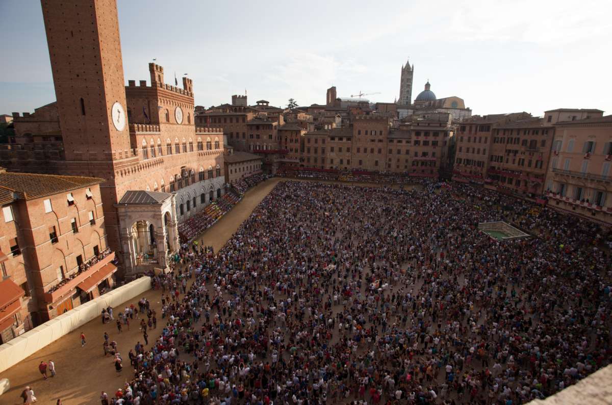 a photo of a large crowd gathering at Piazza del Campo for Palio di Siena
