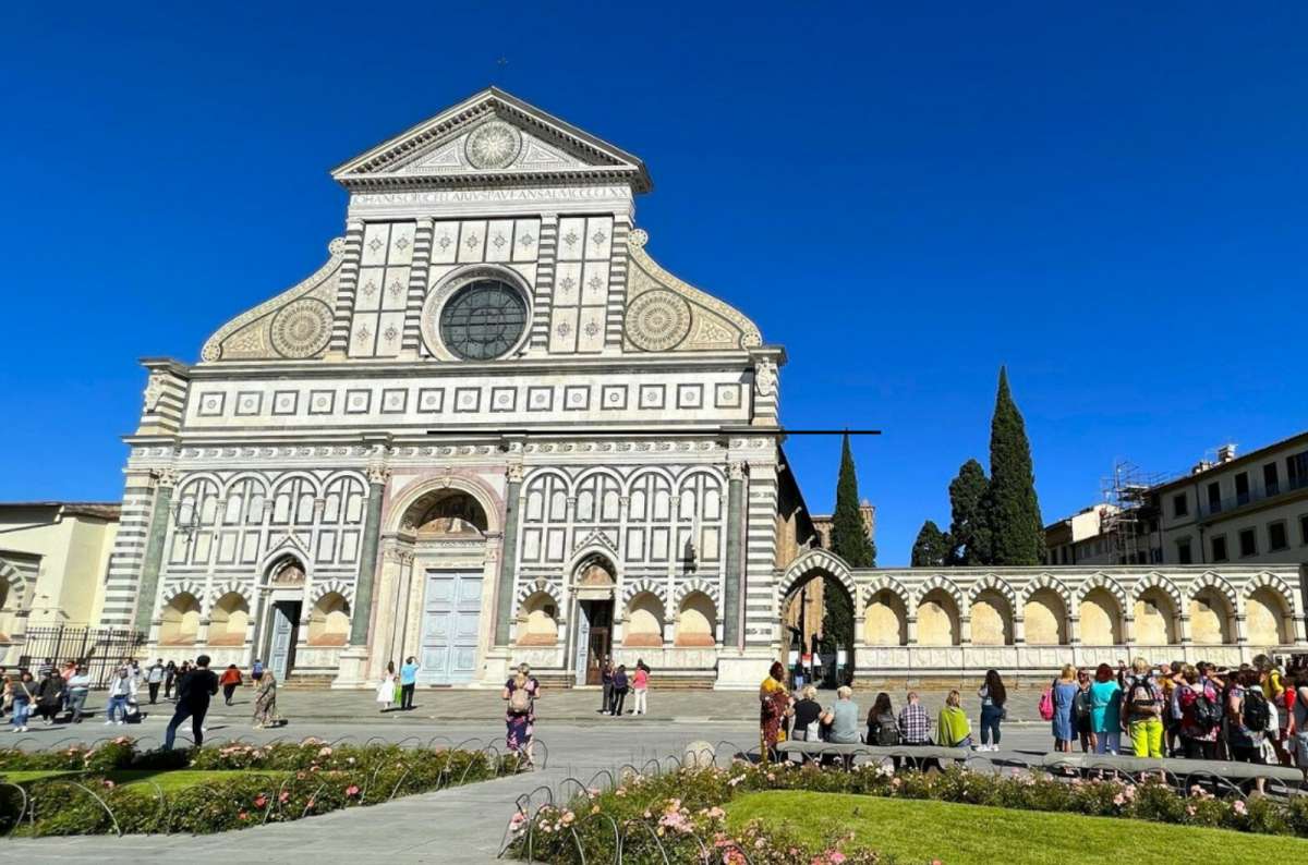 Basilica of Santa Maria Novella, Florence, Italy, with its iconic marble façade and arched colonnade on a sunny day