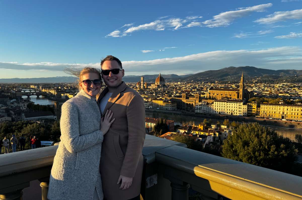 Couple posing at Piazzale Michelangelo with panoramic view of Florence, Tuscany, Italy, including Florence Cathedral, photo by Next Level of Travel
