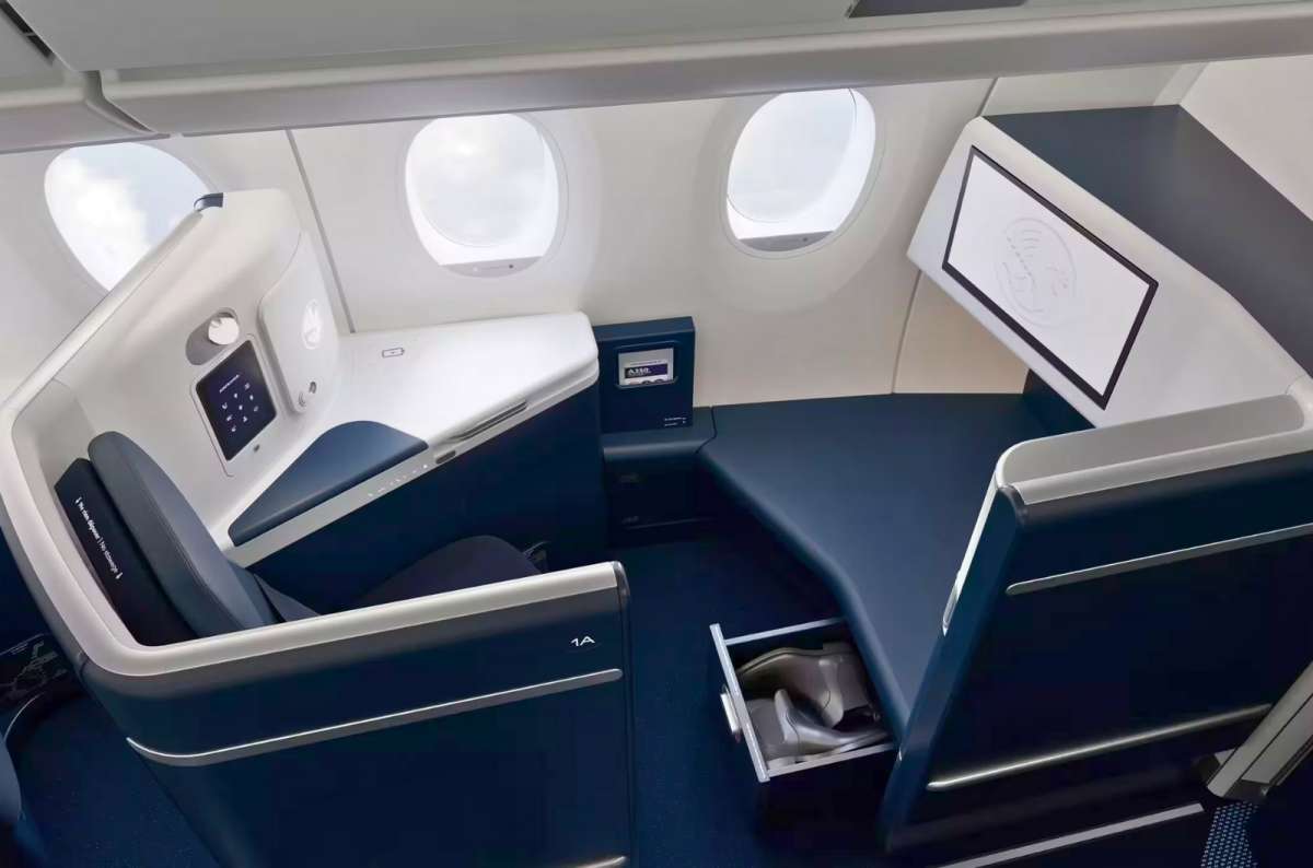 First Class airplane seat converted into a flat bed with extra legroom and storage