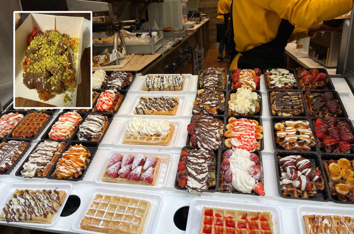 A colorful display of Belgian waffles topped with whipped cream, strawberries, and other toppings at a waffle shop in Brussels, Belgium, photo by Next Level of Travel
