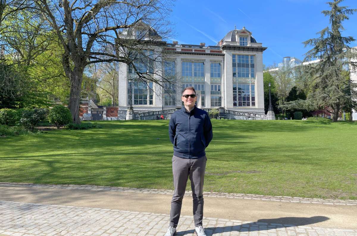 Man standing in front of the Royal Greenhouses of Laeken in Brussels, Belgium – photo by Next Level of Travel