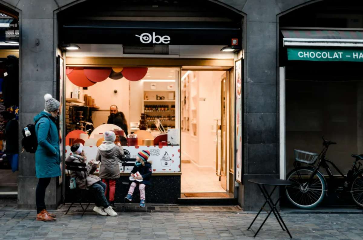 People enjoying waffles outside Obe Belgian Waffles shop near Grand Place in Brussels, Belgium