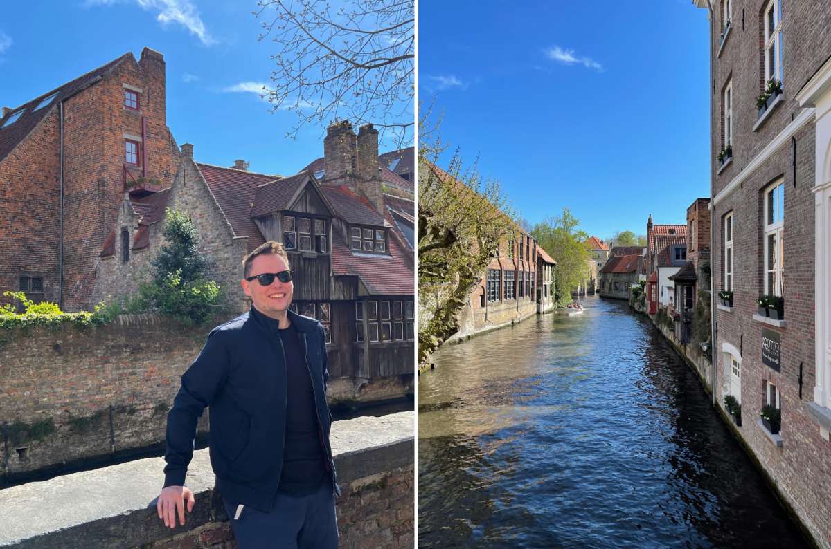Man smiling in front of charming medieval buildings and canal in Bruges, Belgium, with typical brick houses and overhanging wooden windows, on a sunny spring day, photo by Next Level of Travel