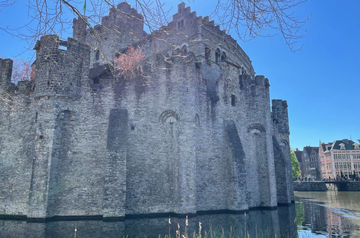 a photo of Gravensteen castle and the surrounding moat, Ghent, Belgium, taken on a sunny day with blue sky, photo by Next Level of Travel