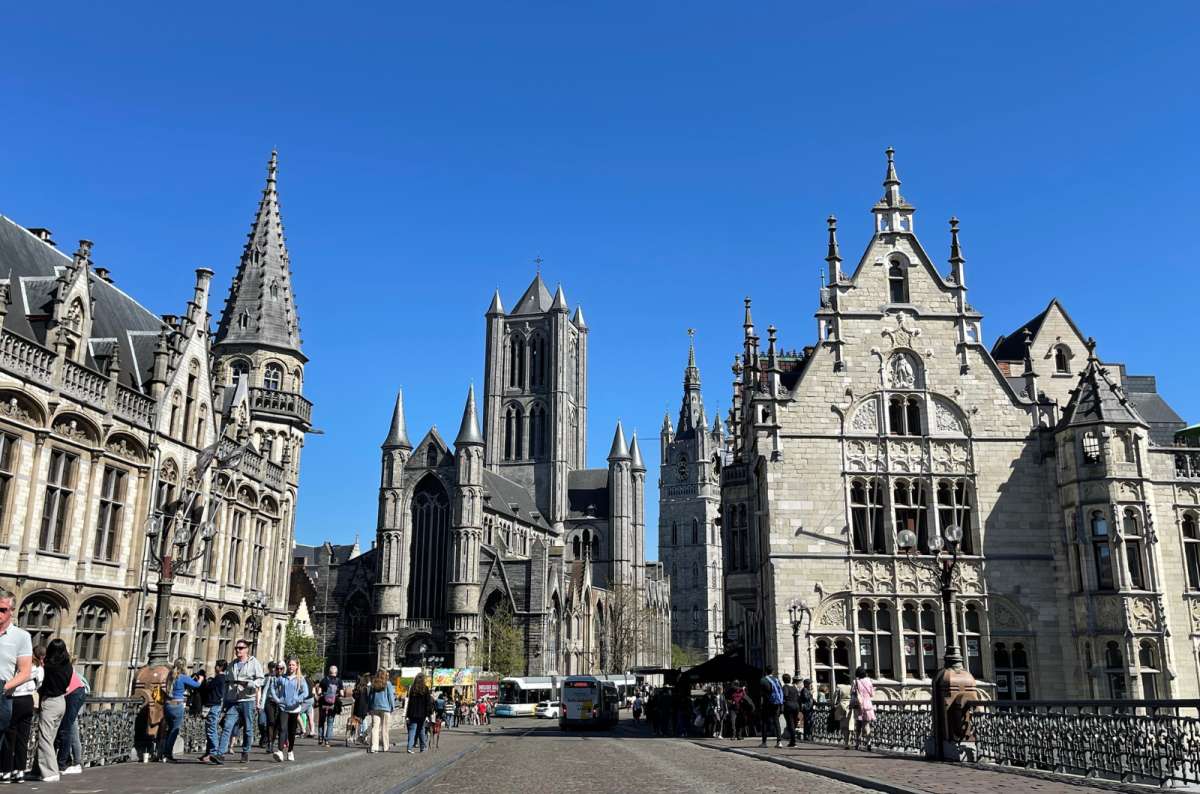 a photo of the Ghent city center in broad daylight with St. Nichola’s Church and smaller crowds roaming the city streets, Ghent, Belgium, photo by Next Level of Travel