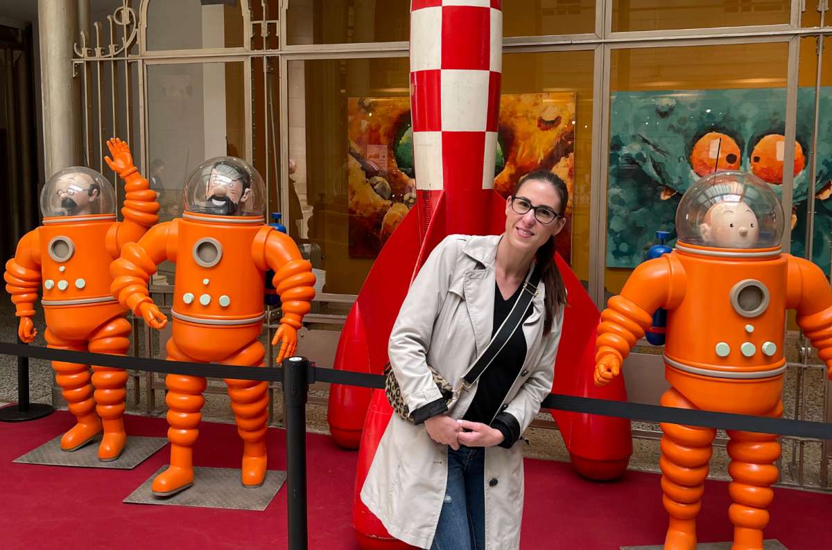 Female tourist with exhibit showing Tintin rocket and characters in spacesuits at the Comics Art Museum in Brussels, photo by Next Level of Travel