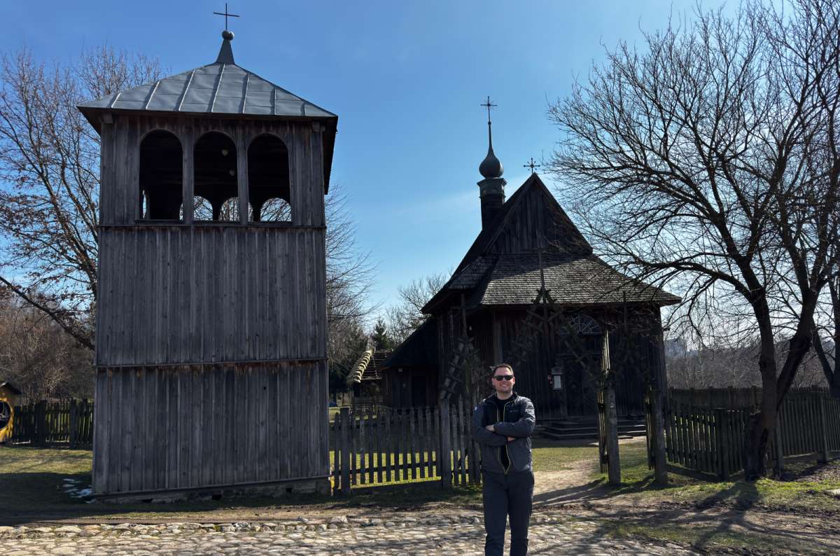 a photo of a tourist posing in front of old-style buildings in the open-air museum in Lublin, Poland, photo by Next Level of Travel