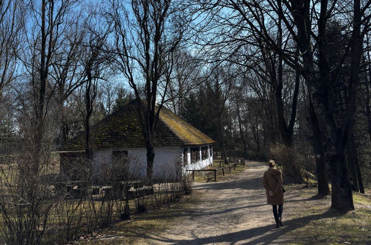 a photo of a tourist taking a walk in the Lublin open-air museum with beautiful nature all around, Lublin, Poland, photo by Next Level of Travel