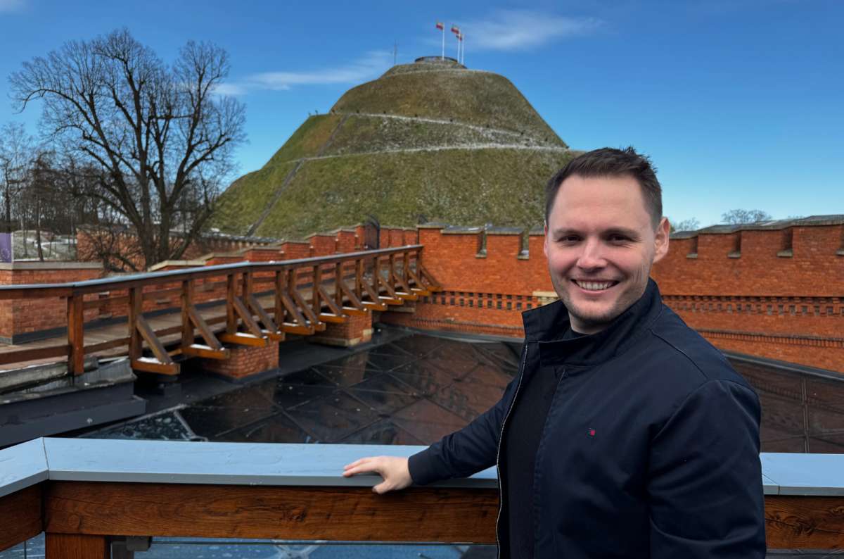 a photo of a tourist posing in front of Kosciuszko Mound, Krakow, Poland, photo by Next Level of Travel