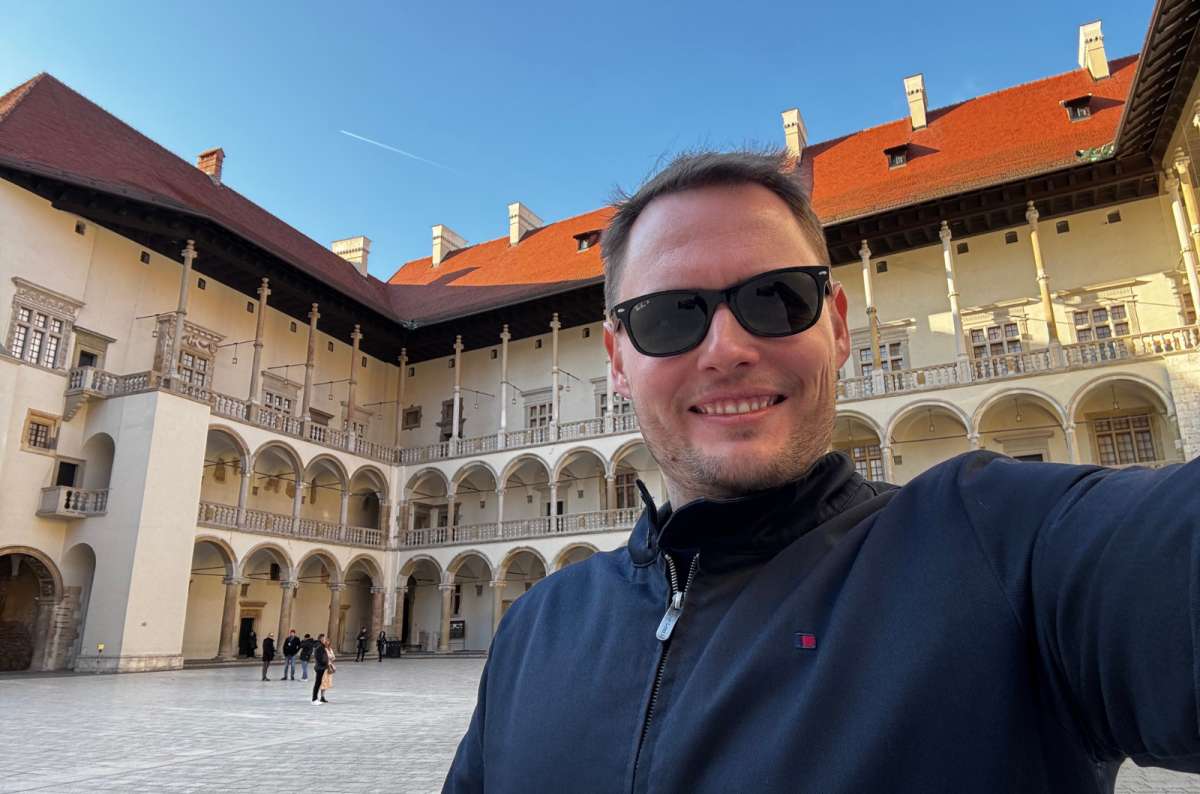 a photo of a tourist posing in the Wawel Castle area, Krakow, Poland, photo by Next Level of Travel