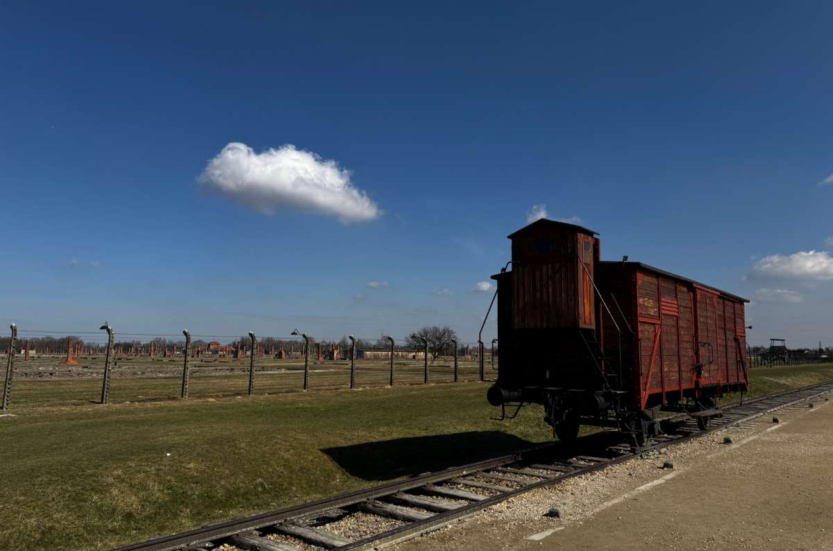 a photo of an old train on the tracks leading to the Auschwitz concentration camp, Oświęcim, Poland, photo by Next Level of Travel