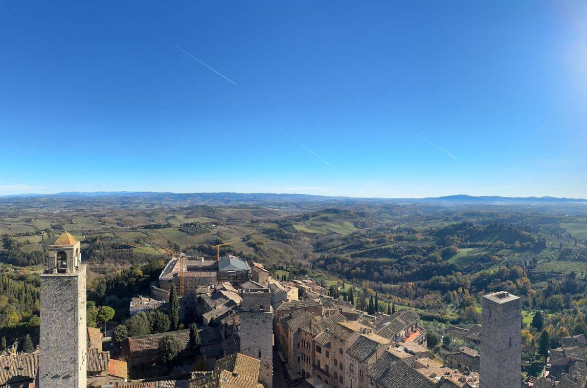 a panoramic photo of San Gimignano from up above showing the beautiful nature surrounding the city, Italy, photo by Next Level of Travel