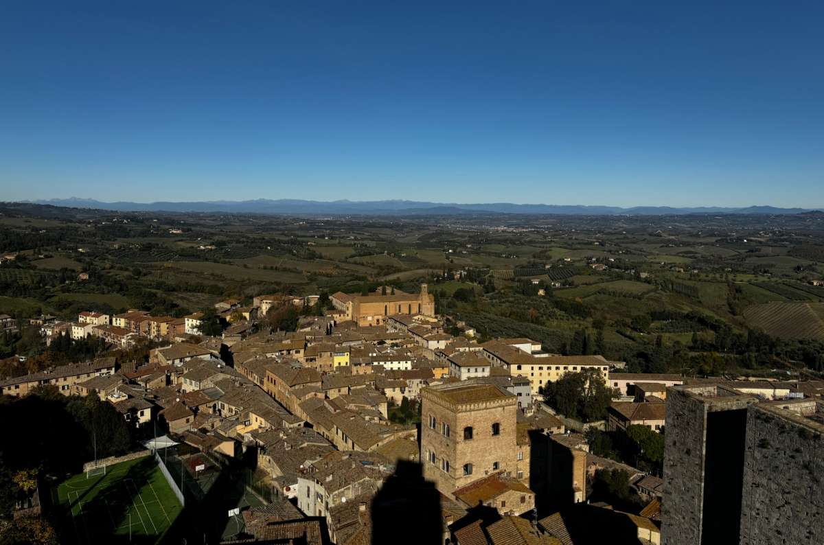 a photo of San Gimignano from up above showing the beautiful architecture in the city on a sunny day, Italy, photo by Next Level of Travel