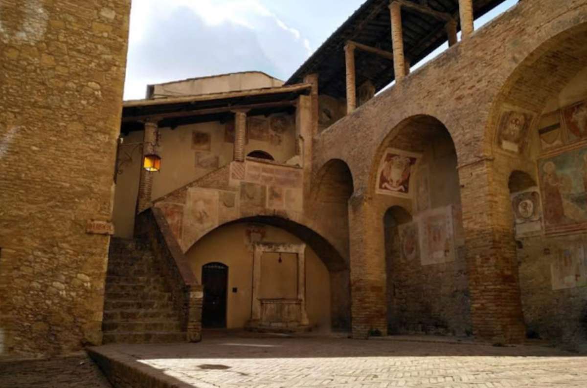 a photo of the Palazzo Comunale courtyard showing the intricate decorations, San Gimignano, Italy