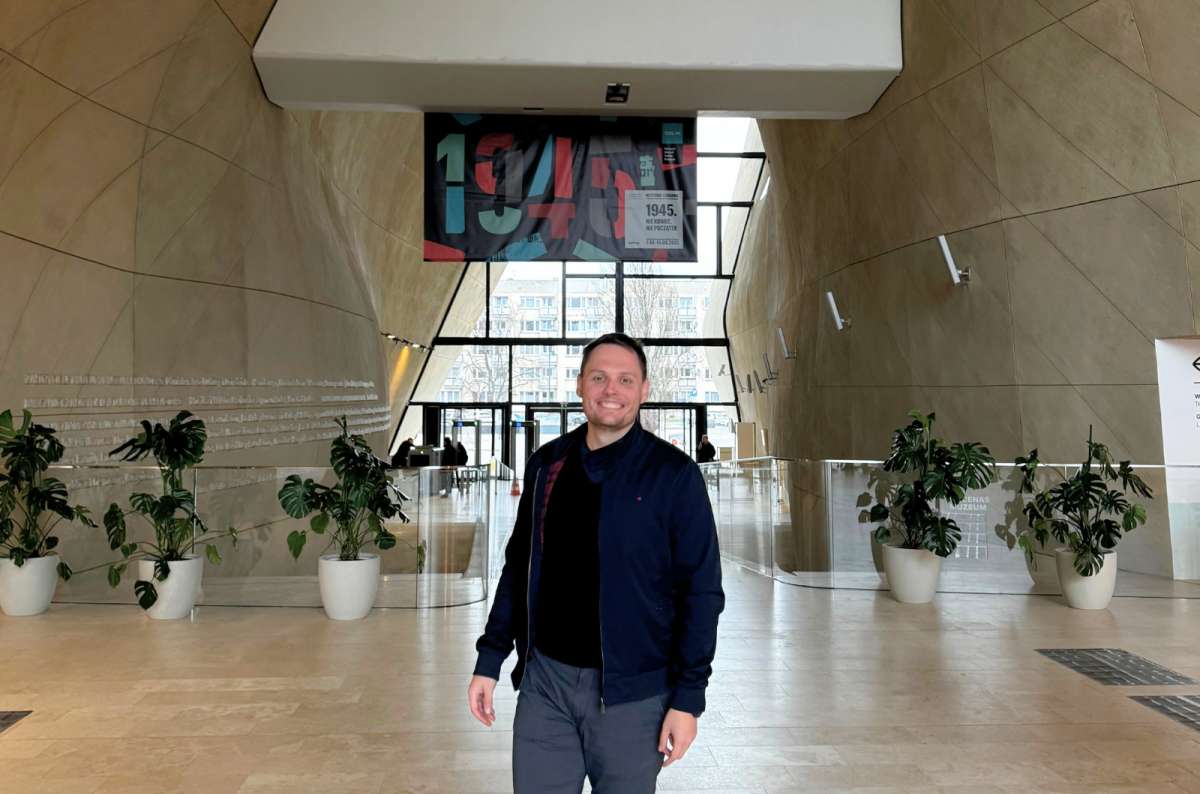 Traveler standing inside the modern entrance hall of the POLIN Museum of the History of Polish Jews in Warsaw, Poland, photo by Next Level of Travel