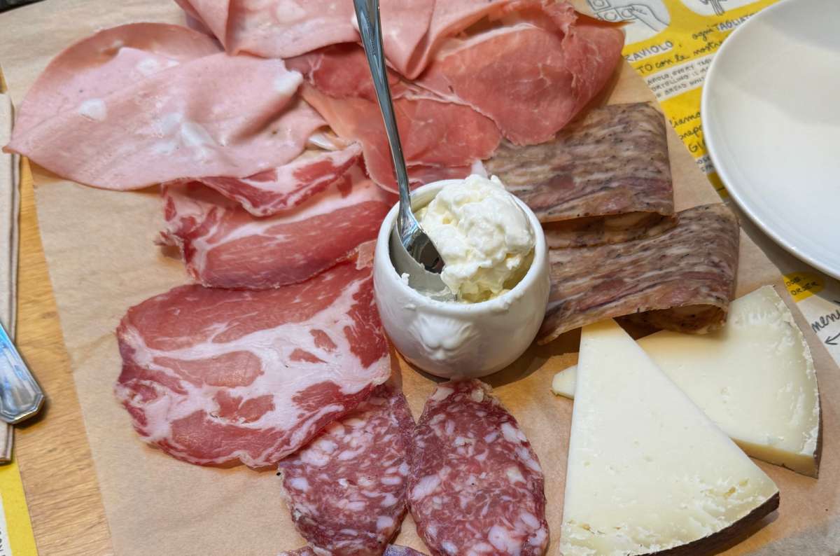 Traditional Italian cold cuts, cheeses, and fresh burrata served on a wooden platter in Bologna, Italy, photo by Next Level of Travel