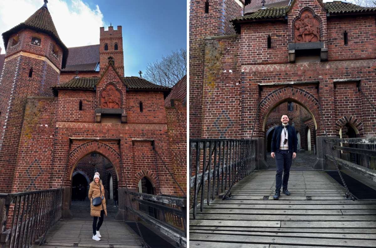 Two travelers standing on the wooden bridge at the entrance of Malbork Castle in Malbork, Poland, photo by Next Level of Travel
