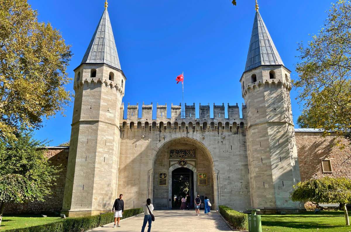 Main gate of Topkapi Palace with twin towers and visitors entering, Istanbul, Turkey, photo by Next Level of Travel