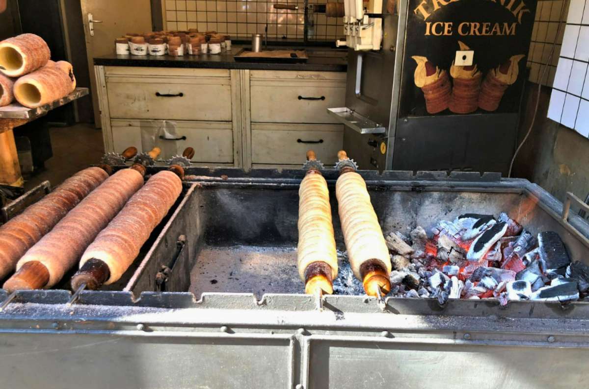 Trdelník pastry roasting over open coals at a street stall in Prague, Czech Republic
