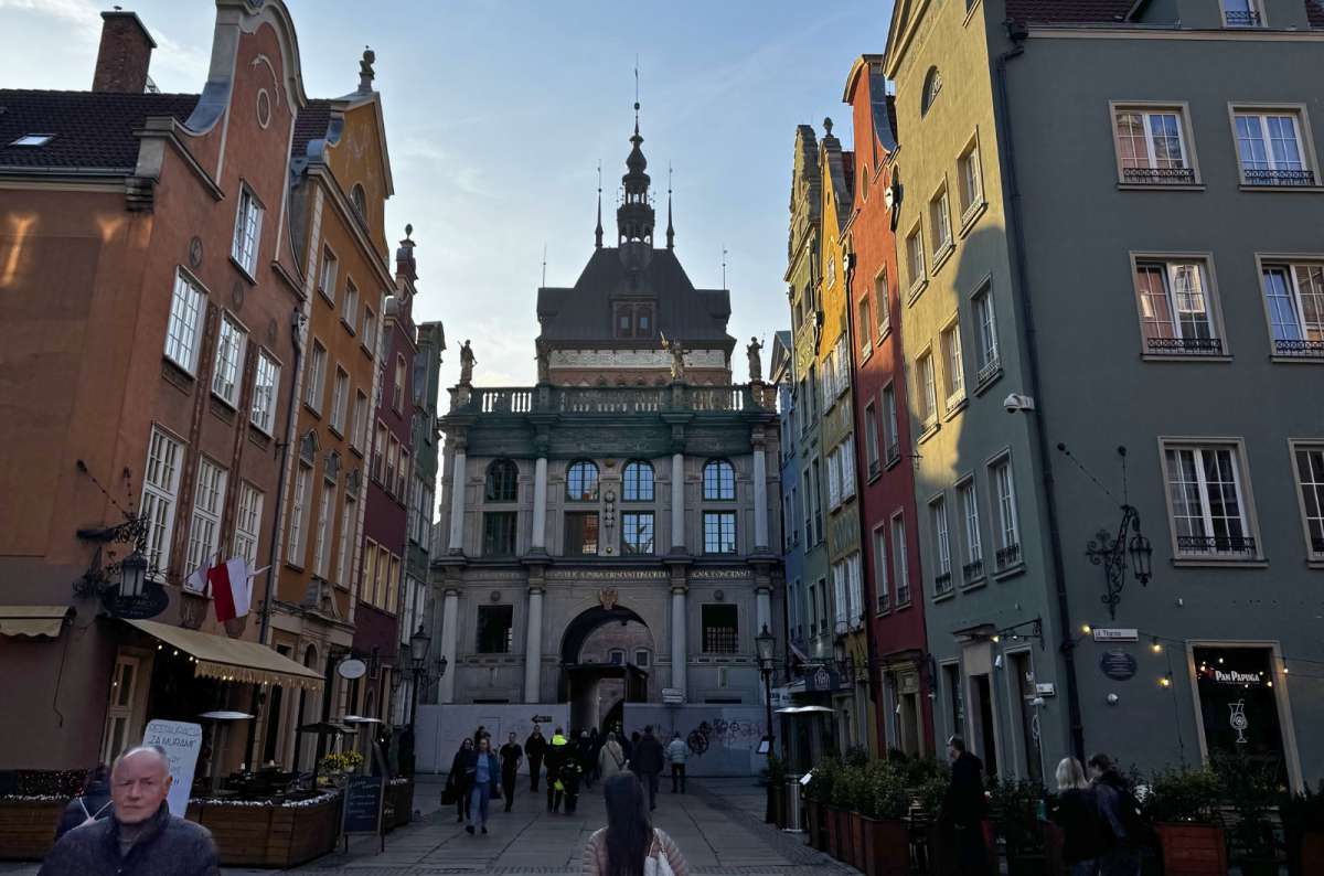 Golden Gate at the end of Długa Street in Gdansk Old Town, Poland, with colorful townhouses lining the street, photo by Next Level of Travel