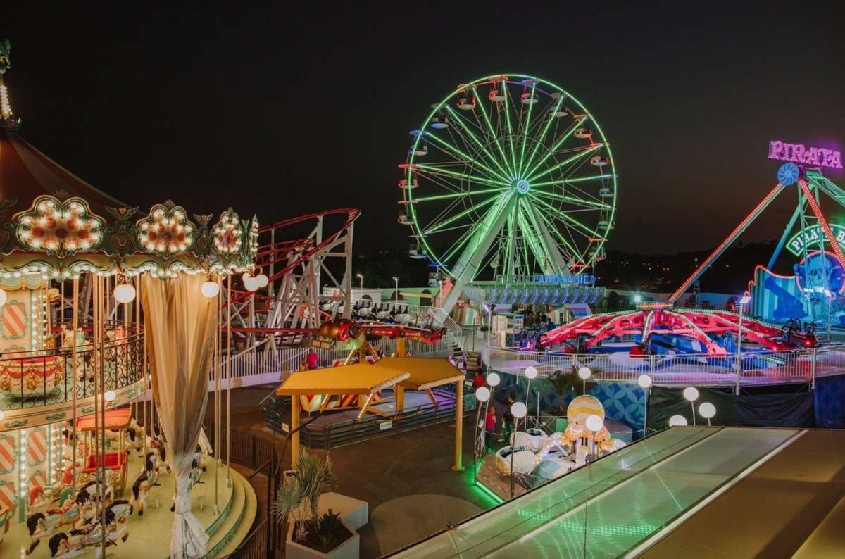 a photo of the Ferris wheel in Holiday World Maspalomas during the nighttime, while the theme park is lit up, Canary Islands
