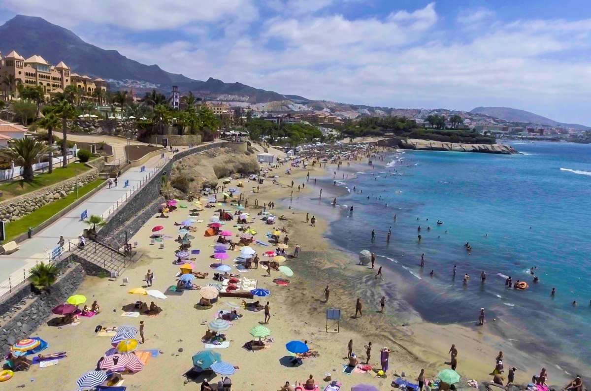 Playa de las Américas beach with tourists and umbrellas in South Tenerife, Spain