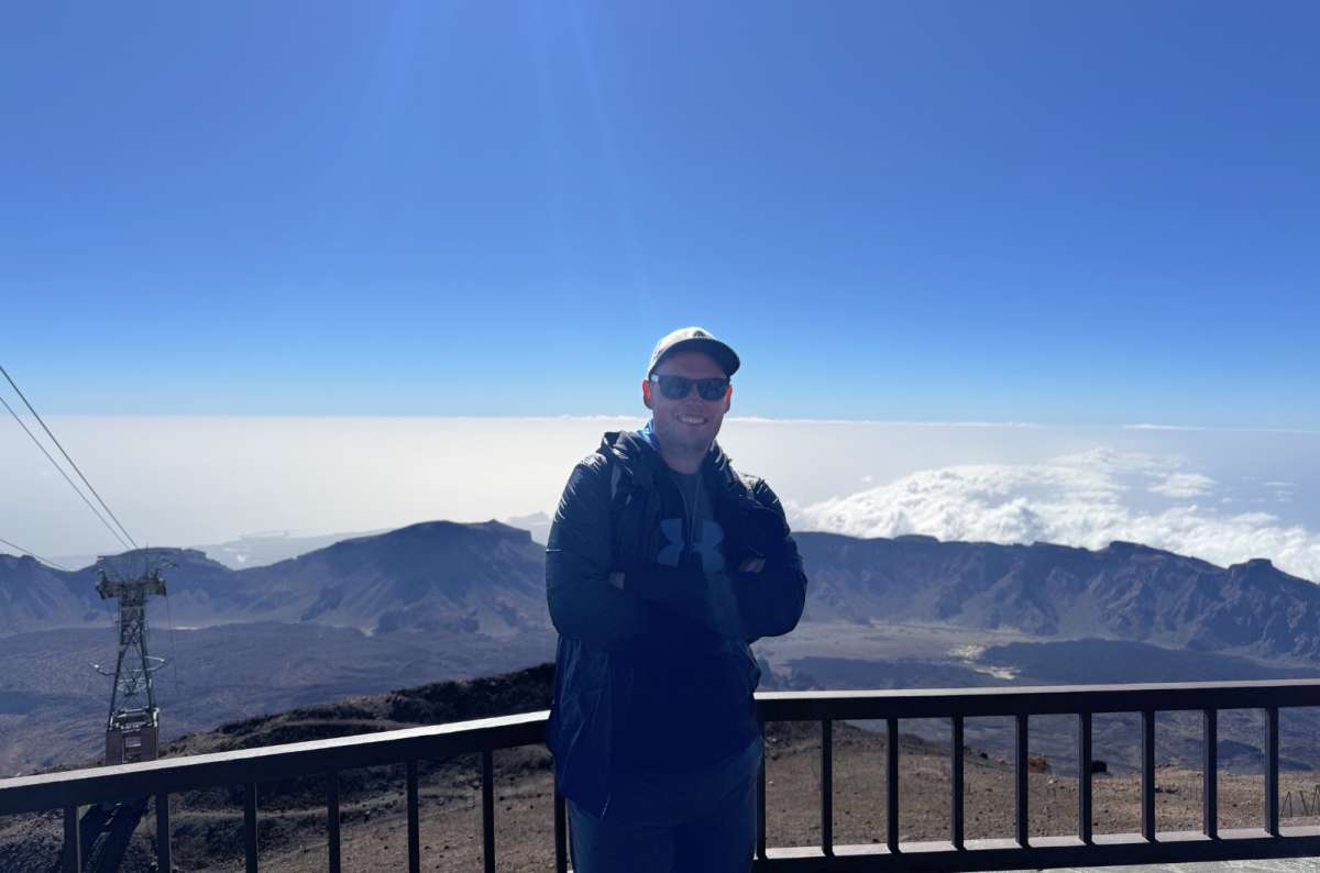 a photo of a tourist posing at the top of Mt. Teide in Teide National Park and Tenerife landscapes, Canary Islands, photo by Next Level of Travel