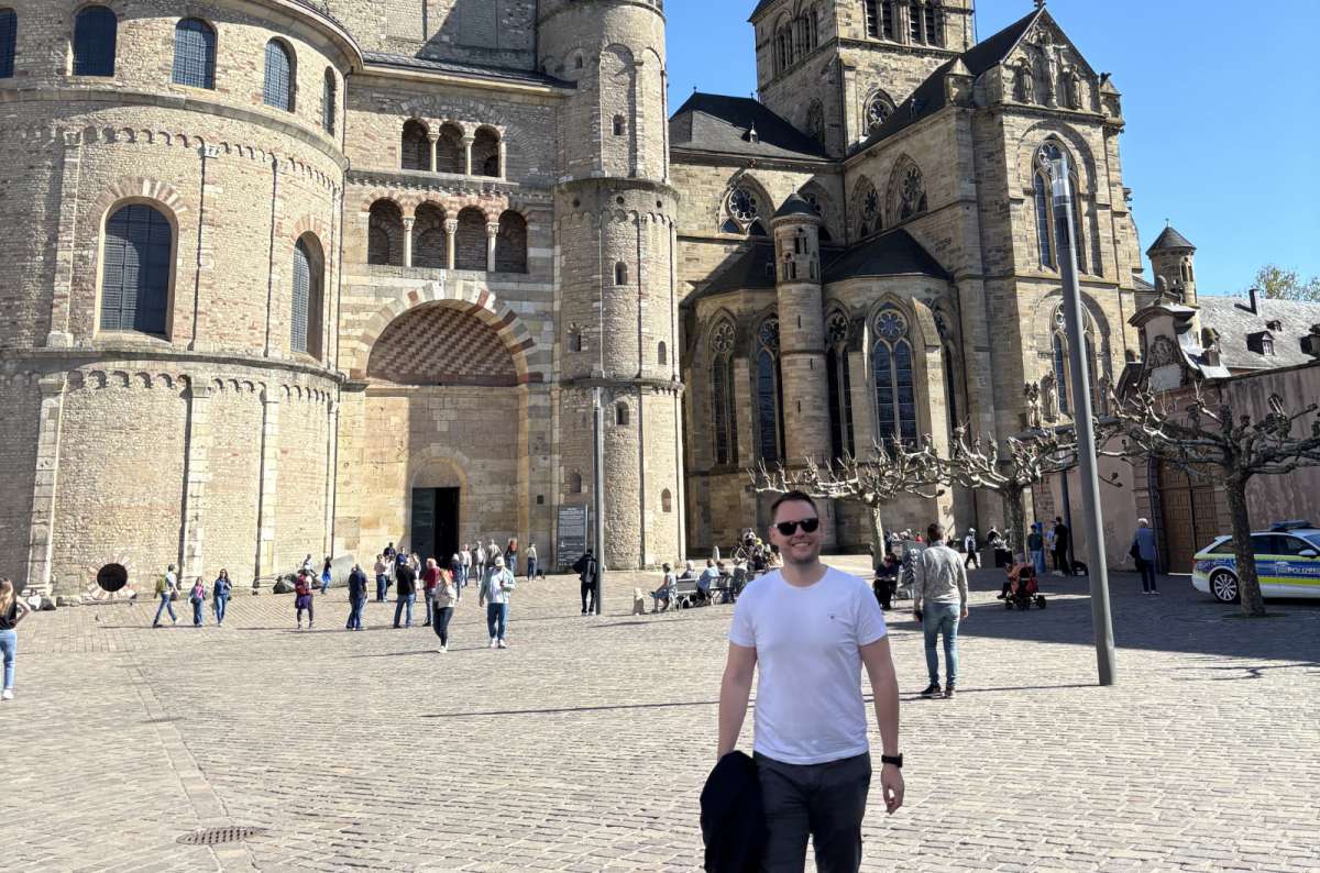 a photo of a tourist posing in front of the Trier Cathedral, Germany, photo by Next Level of Travel