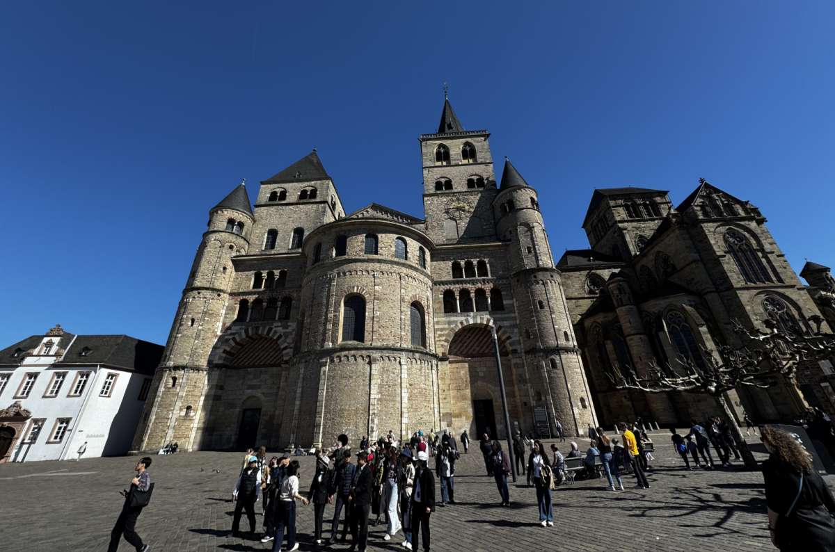 a photo of the Trier Cathedral from the outside, showing the crowds of tourists gathering in front, Trier, Germany, photo by Next Level of Travel