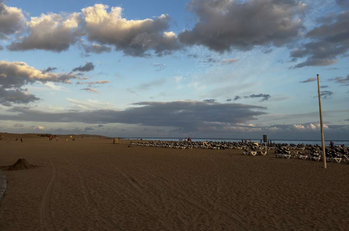 a photo of Playa del Inglés, showing crowds sitting by the sea, \Canary Islands, photo by Next Level of Travel