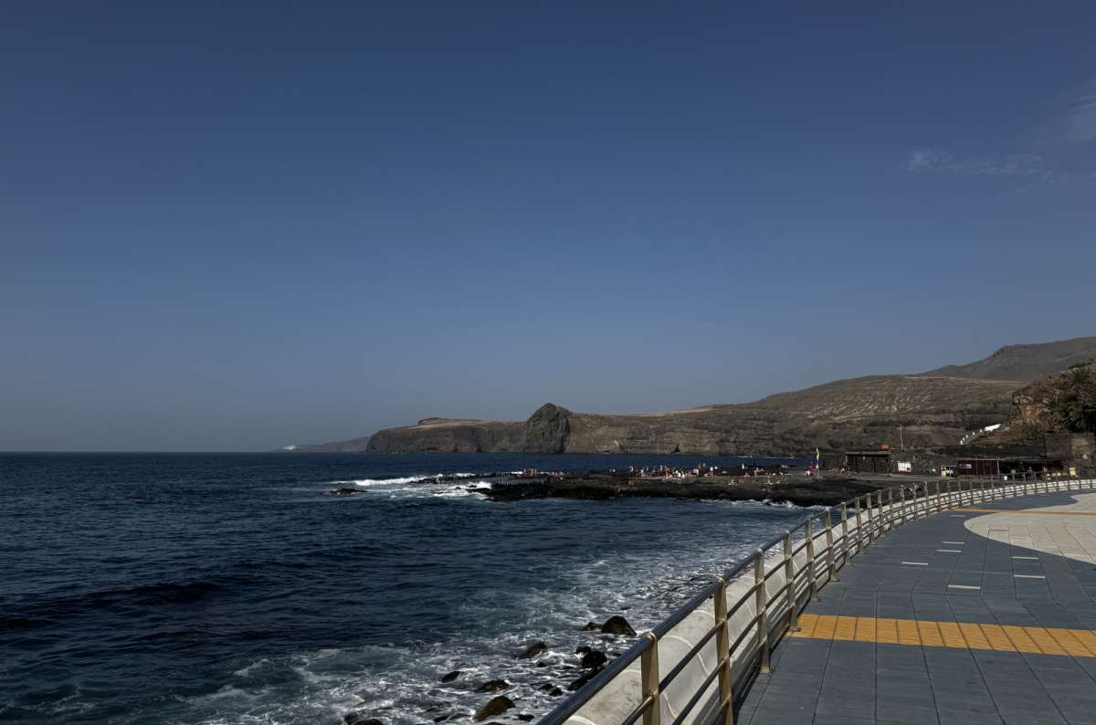 a photo of the Agaete promenade and natural pools in Gran Canaria, with the rocky coastline and cliffs visible in the background, Canary Islands, photo by Next Level of Travel