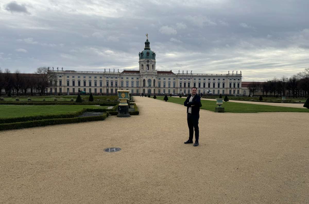 a photo of a tourist posing in front of Charlottenburg in Berlin, Germany, photo by Next Level of Travel