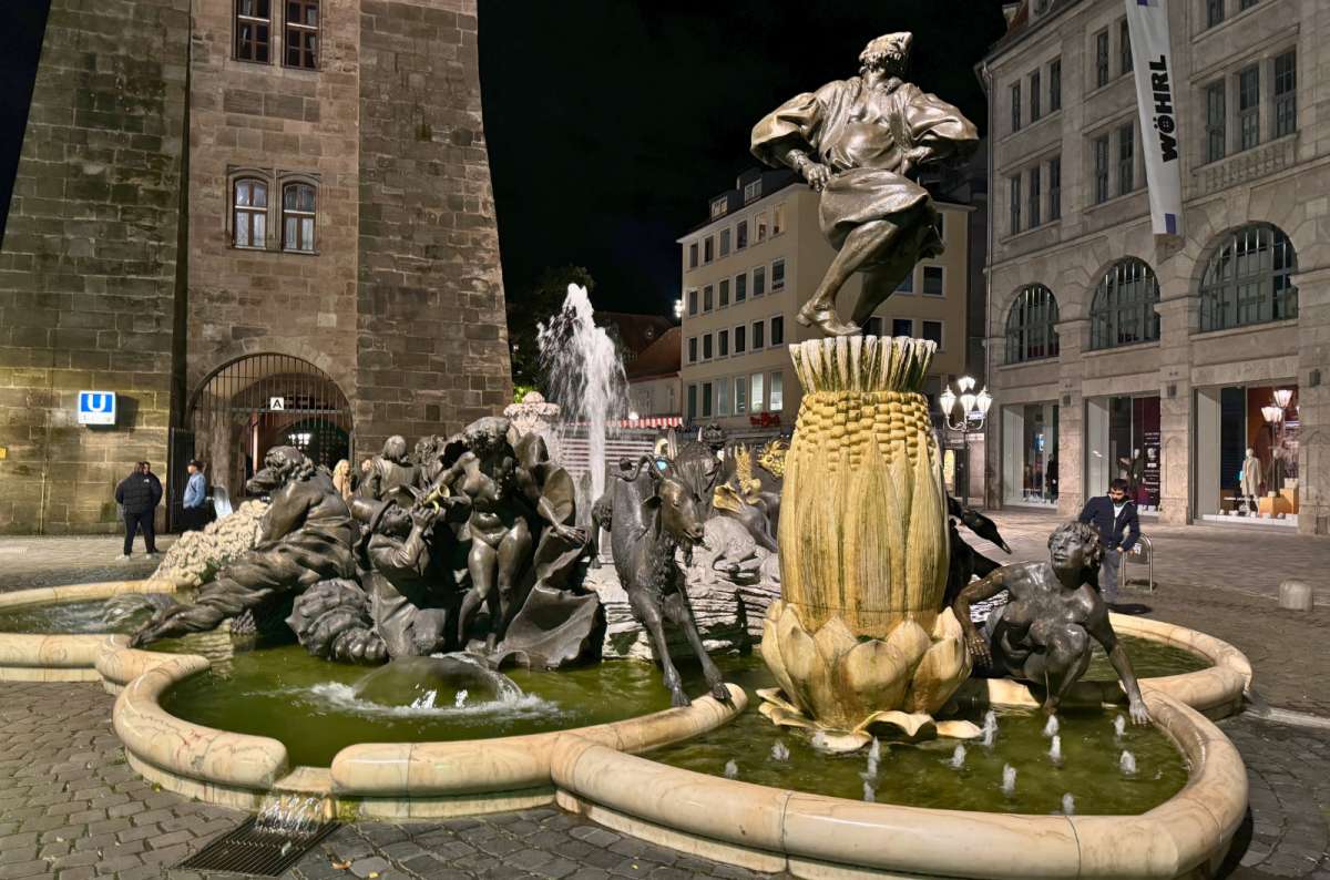 Ehekarussell Fountain illuminated at night near White Tower in Nuremberg, Germany, photo by Next Level of Travel