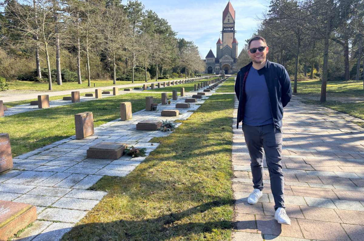 Visitor walking through Mahnmal Cemetery at Leipzig, Germany, with memorial chapel in the background, photo by Next Level of Travel