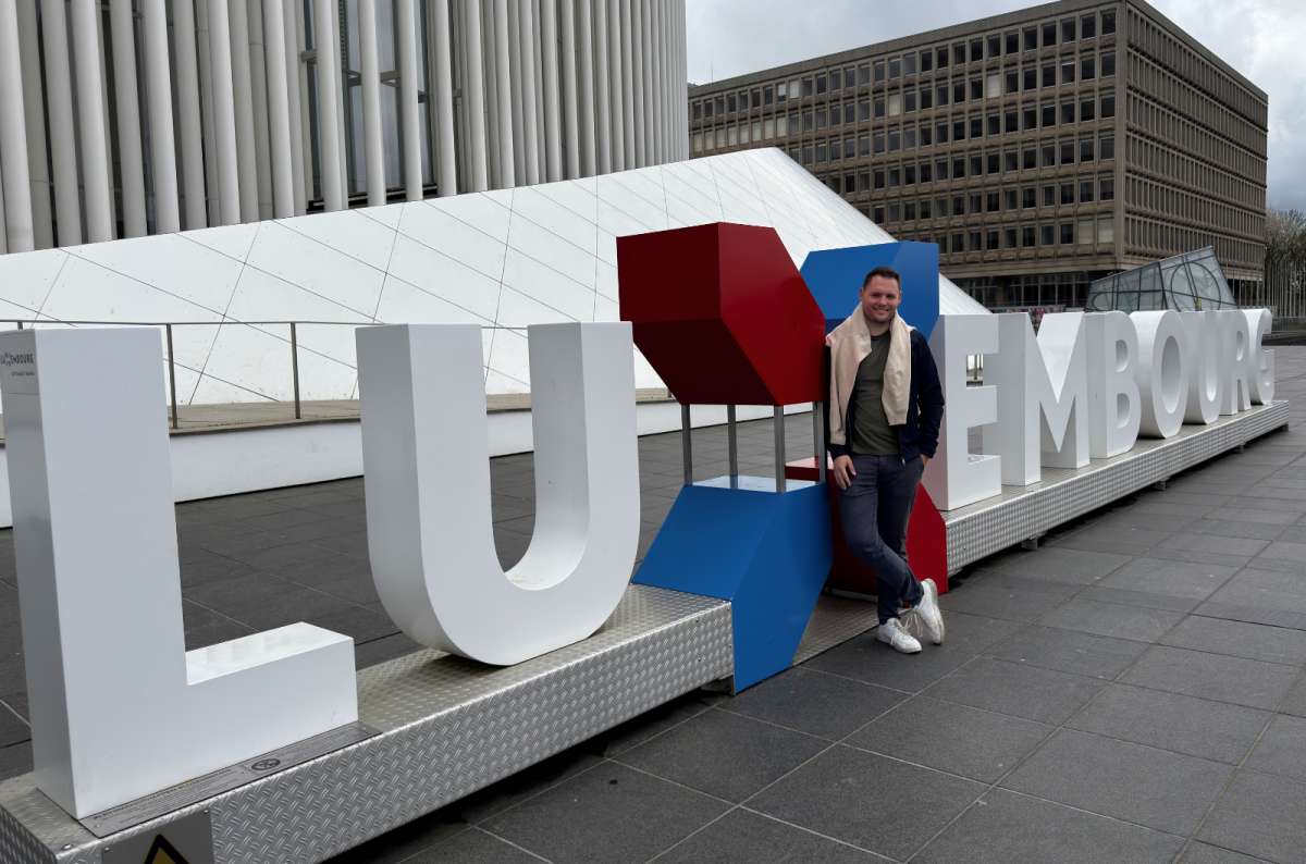 Tourist at the Luxembourg sign in Place de l'Europe, Kirchberg, Luxembourg City, Luxembourg, photo by Next Level of Travel