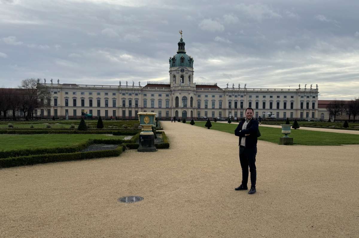 a photo of a tourist posing in front of Charlottenburg Palace in Berlin, Germany, photo by Next Level of Travel