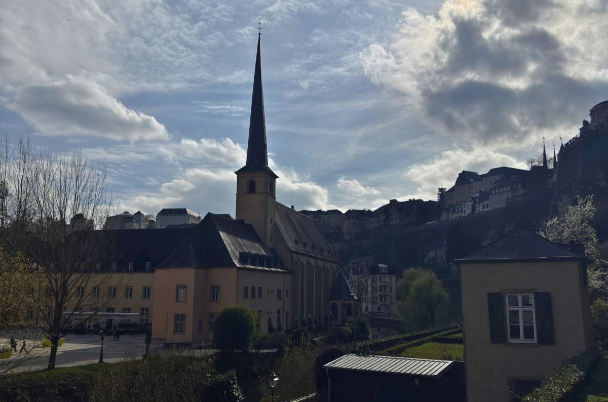 Neimënster Abbey's spire silhouetted above the Grund at dusk, Luxembourg City, Luxembourg, photo by Next Level of Travel