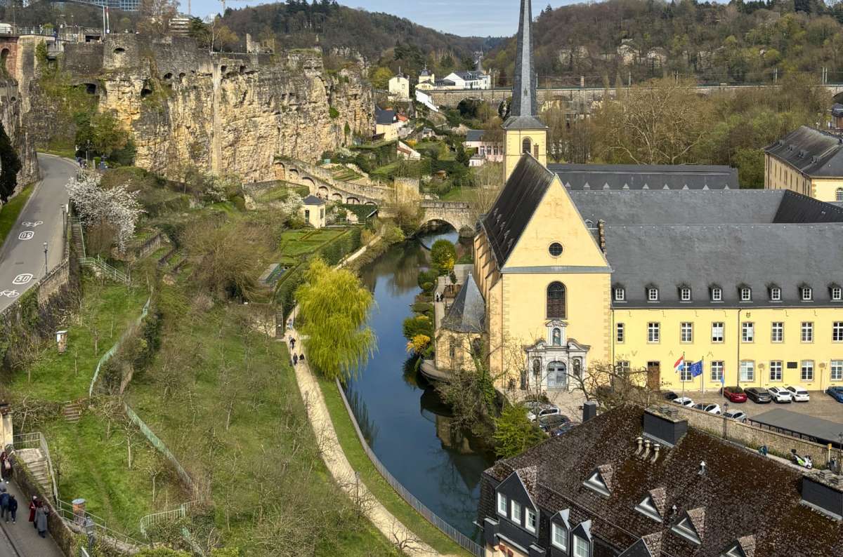 View of Grund, Alzette River, Neumünster Abbey, and the cliffs below Ville Haute in Luxembourg City, Luxembourg, photo by Next Level of Travel