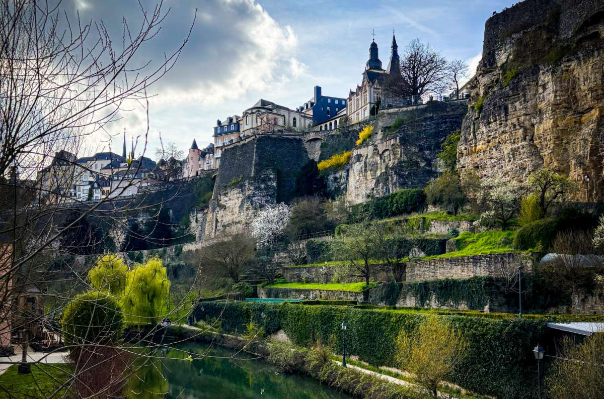 View of the Grund district, Alzette River, and fortifications beneath Luxembourg City's upper cliffs, photo by Next Level of Travel