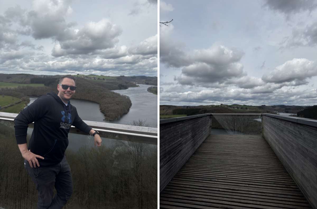 a tourist posing on top of the Burfelt viewing platform with the river and forests visible in the background, photo by Next Level of Travel