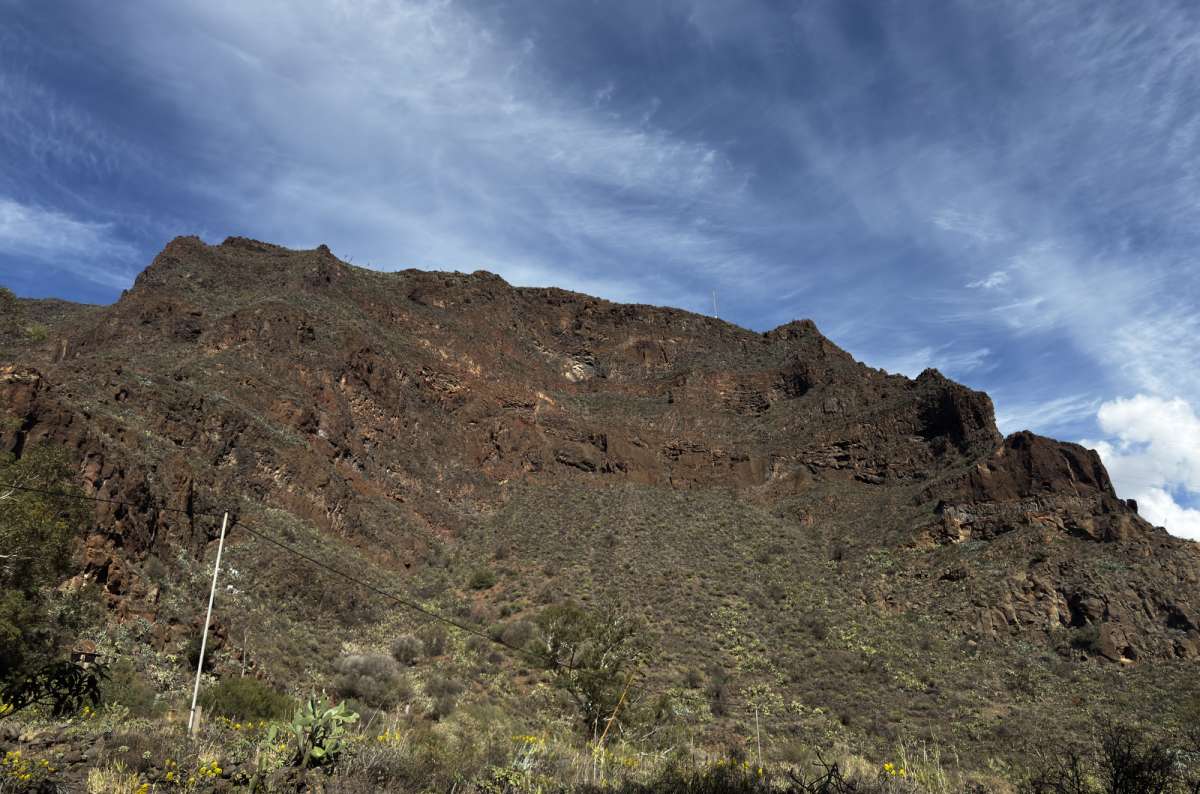 a dramatic volcanic mountain face with agave plants in the foreground, Gran Canaria, Canary Islands, photo by Next Level of Travel