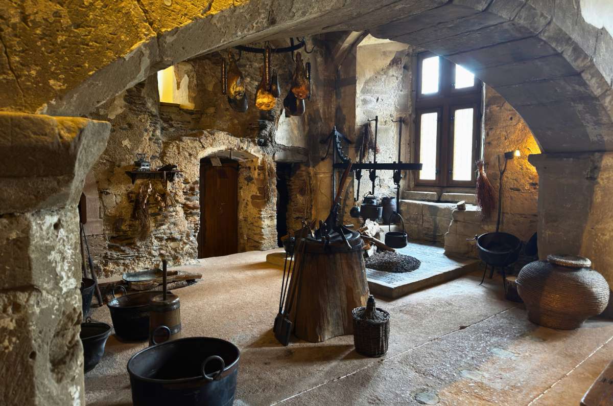 Medieval castle kitchen with a stone fireplace and historic cooking equipment inside Vianden Castle in Vianden, Luxembourg, photo by Next Level of Travel