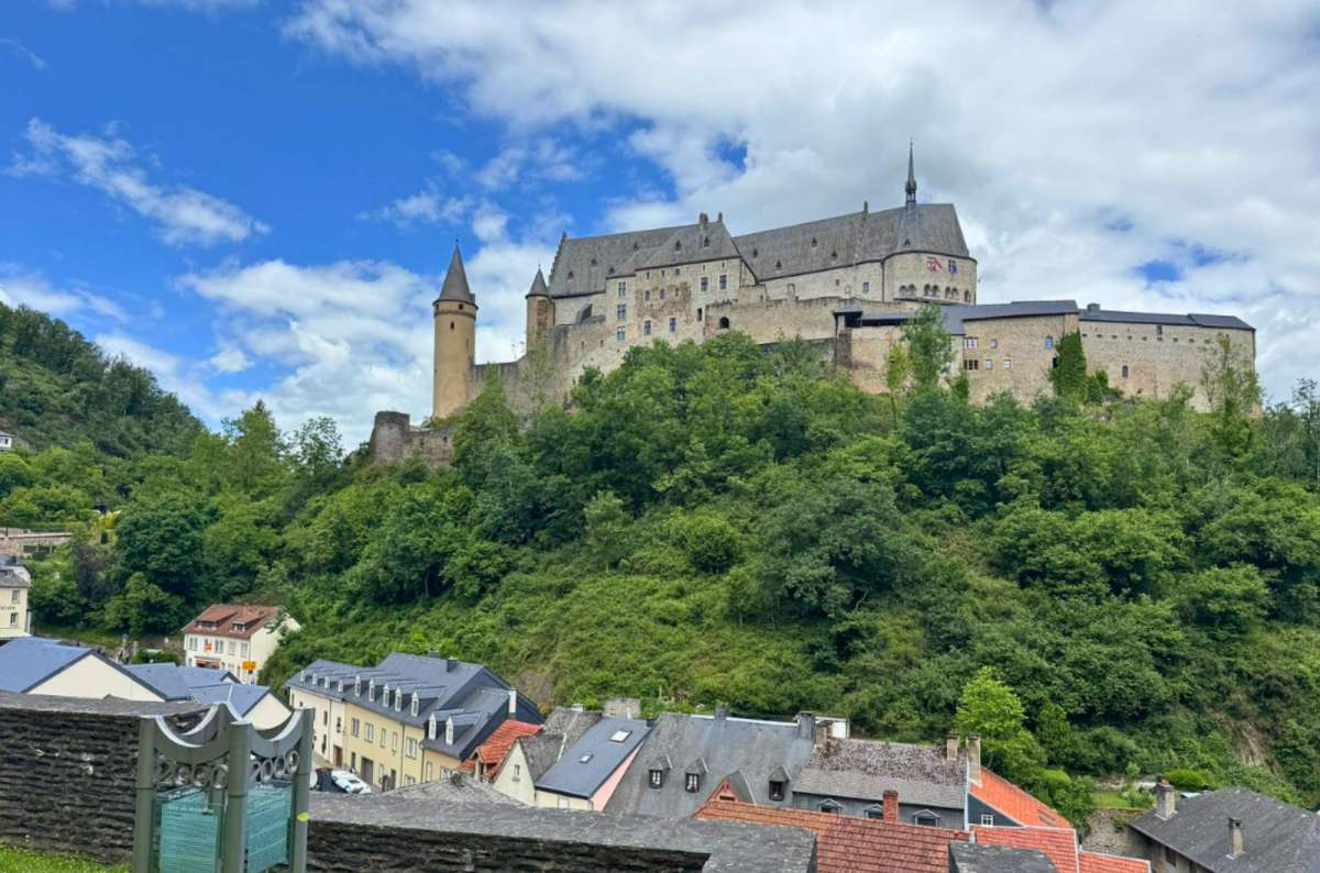 View of Vianden Castle towering above the town from a nearby parking area in Vianden, Luxembourg