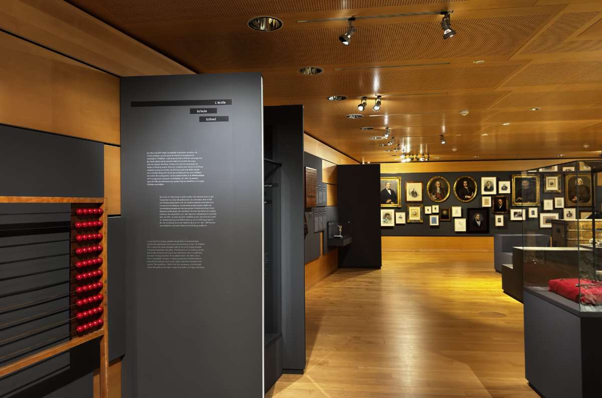 A lamplit museum gallery with display cases and panels, Luxembourg City, Luxembourg, photo by Next Level of Travel