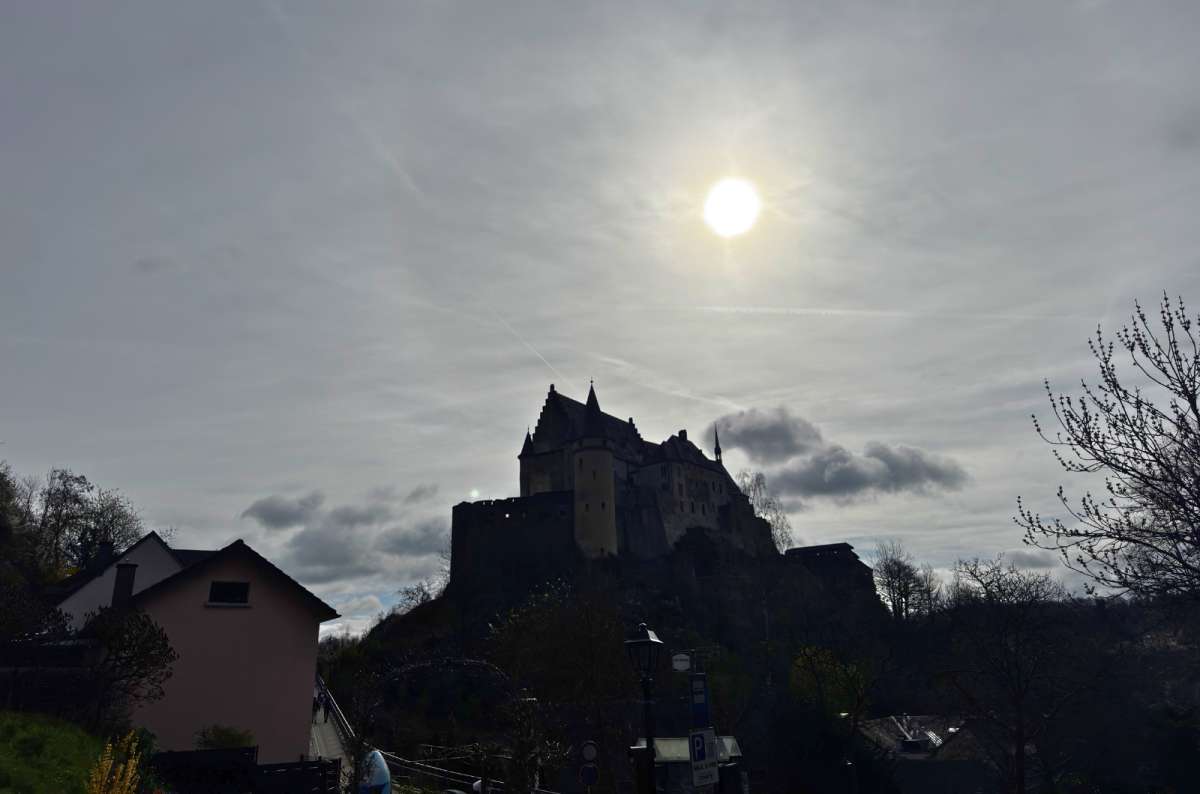 Vianden Castle silhouetted on its rock with the sun behind it, Vianden, Luxembourg, photo by Next Level of Travel