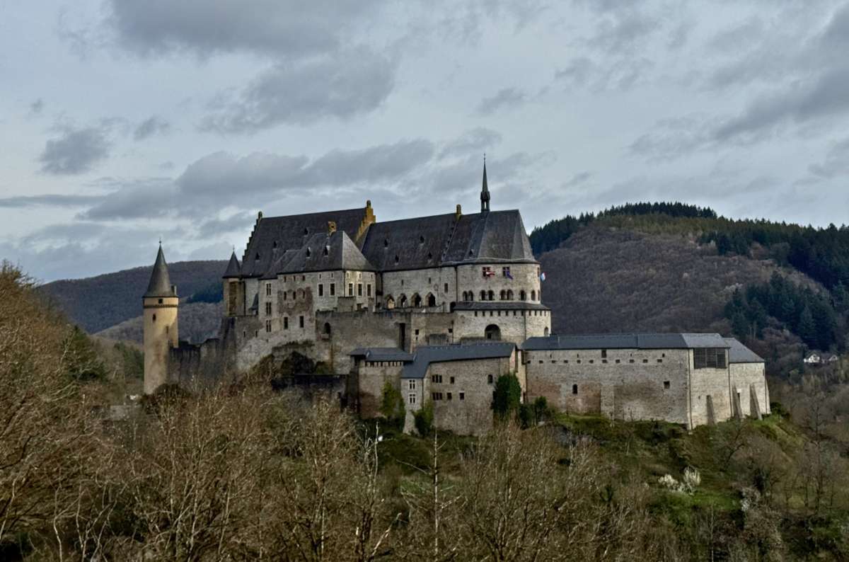 Vianden Castle stretched along its ridge above the wooded valley, Vianden, Luxembourg, photo by Next Level of Travel