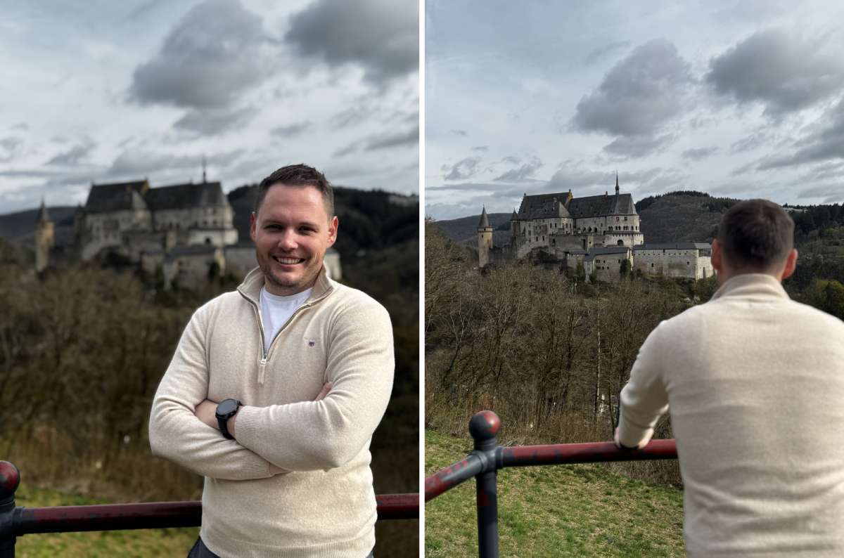 a photo of a tourist in front of Vianden Castle across the valley, Vianden, photo by Next Level of Travel