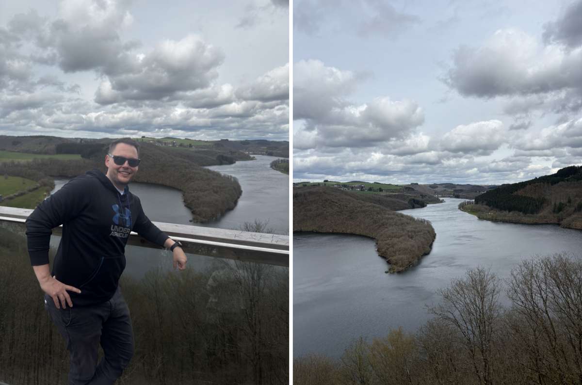 a photo of a tourist at a viewpoint above the Upper Sûre lake and forested hills, Burfelt, Luxembourg, photo by Next Level of Travel 